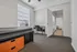 Bright bedroom with modern furnishings, including a single bed, versatile desk, and ample natural light from large windows.