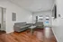 Modern living room with sleek gray sofas, hardwood flooring, and ample natural light from large windows.
