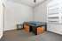 Bright bedroom with elegant furnishings, featuring a comfortable bed with built-in storage and a sleek side table, complemented by a large window for abundant natural light.
