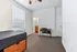 Inviting bedroom with large window, cozy carpet, convenient desk setup, and access to private en-suite bathroom.