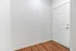 Inviting entryway with sleek wooden floors and a modern white door, offering a warm welcome to a stylish apartment interior.