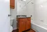 Charming bathroom with stylish wooden vanity, sleek countertop, and pristine white bathtub for a modern living experience.