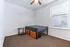 Cozy bedroom with a modern bed frame, built-in storage, and abundant natural light from large window blinds.
