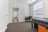 Bright and inviting bedroom with a cozy carpet, ample natural light, and a sleek workspace for productivity.