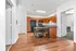 Inviting open-plan kitchen and dining area with sleek wooden floors and modern appliances, perfect for comfortable living.