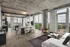 Chic open-concept living space with floor-to-ceiling windows offering stunning city views, featuring a modern kitchen and elegant dining area.