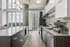Contemporary kitchen with sleek cabinetry, large windows offering panoramic city views, modern appliances, and elegant lighting.