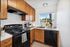 Charming kitchen with wooden cabinets, modern appliances, and a scenic window view.