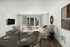 Bright living room with modern decor, plush seating, and large sliding glass doors leading to a patio.