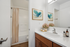 Elegant bathroom with modern vanity, large mirror, and warm wooden accents.