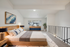 Stylish bedroom featuring a wooden bed, cozy carpet, and contemporary artwork.