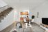 Contemporary living room and kitchen with open-concept design, featuring a stylish dining area and stairway.