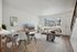 Inviting living room featuring a light-filled space with modern furniture, a cozy sofa, and a sleek dining area.