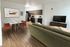 Sophisticated open-concept living area with a stylish dining set, modern kitchen, and comfortable seating.
