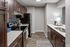 Modern kitchen with stainless steel appliances, hardwood floors, and sleek dark wood cabinets.