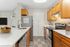 Modern kitchen with sleek white countertops, stainless steel appliances, and warm wooden cabinetry, offering a stylish and functional cooking space.