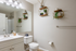 Elegant bathroom with modern decor, featuring a vanity with under-sink storage, large mirror, and stylish geometric wall shelves with plants.