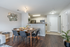 Modern dining area with stylish decor, open kitchen, and elegant wood flooring, exuding a cozy and inviting ambiance.
