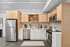 Modern kitchen with sleek stainless steel appliances, light wood cabinetry, and open shelving for a stylish, functional space.