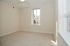 Bright and airy bedroom with plush carpet, large window, and neutral tones for a cozy atmosphere.