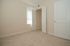 Bright and inviting bedroom with plush carpeting, large closet space, and natural light streaming through the window.