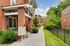 Charming red brick apartment complex with lush greenery and a welcoming entrance walkway.