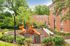 Charming apartment complex with a vibrant playground surrounded by lush greenery, perfect for families.