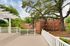 Charming apartment complex nestled amid lush greenery with a spacious outdoor deck and classic brick facade.