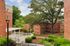 Charming apartment view showcasing lush green landscaping, red brick buildings, and a vibrant community space with a playground.