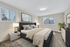 Elegant bedroom with a plush king-size bed, modern decor, and large windows offering scenic views.