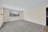 Bright, spacious room with plush carpeting, large window for natural light, and neutral walls, offering a blank canvas for your dream decor.