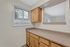Bright and inviting kitchen nook featuring ample countertop space, elegant wooden cabinets, and a large window providing natural light.