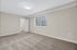 Bright and spacious bedroom with soft carpet flooring, large window inviting natural light, and a convenient walk-in closet.