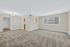 Bright and airy living space with plush carpet, large window with tree views, and a charming chandelier.