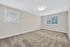 Bright and spacious empty room with plush carpet, large windows, and modern lighting, perfect for personalization.
