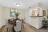 Charming dining area with elegant table setting, modern lighting, and an inviting open kitchen layout, ideal for cozy gatherings.
