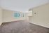 Bright and spacious living area with plush carpeting and large windows offering serene views.