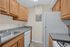 Compact and efficient kitchen with modern cabinetry, stainless steel sink, and sleek countertops.