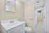 Bright and modern bathroom with sleek white fixtures, ample countertop space, and soft beige walls, creating a welcoming ambiance.