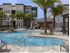 Dwell Nona Place, exterior, sparkling blue swimming pool, palm trees, three story building, club house, palm trees