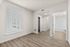 Bright and airy bedroom with modern wood flooring, large window with blinds, and convenient access to an en-suite bathroom.