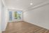 Bright and spacious living room with elegant wood flooring and large windows offering scenic views.