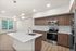Modern open-concept kitchen with elegant wood cabinets, stainless steel appliances, and a sleek island, offering a bright and spacious living area with large windows and scenic views.
