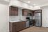 Modern kitchen with sleek stainless steel appliances, elegant wood cabinetry, and contemporary tile backsplash, offering a stylish and functional space.
