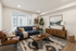 Modern living room with stylish decor, featuring a comfortable blue sofa, elegant wooden coffee table, and large windows for natural light.