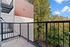 Charming balcony view with lush greenery and modern architecture, perfect for relaxation.