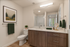 Modern and inviting bathroom featuring a sleek wood vanity with elegant countertop, stylish mirror, and lush greenery accents.
