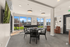 Bright and inviting common area featuring large windows, modern decor, and a versatile round table for social gatherings.