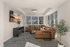 Contemporary living room with a cozy leather sectional, sleek entertainment unit, and expansive windows offering picturesque views.