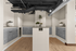 Modern mailroom with elegant wooden flooring, sleek gray mailboxes, and stylish potted plants adding charm to the space.
